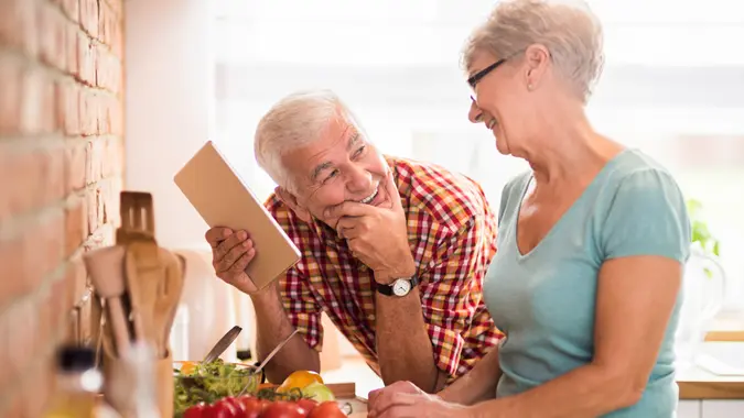 Two couples reviewing investment plans together, discussing financial strategies for a secure retirement. Two couples reviewing investment plans together, discussing financial strategies for a secure retirement.